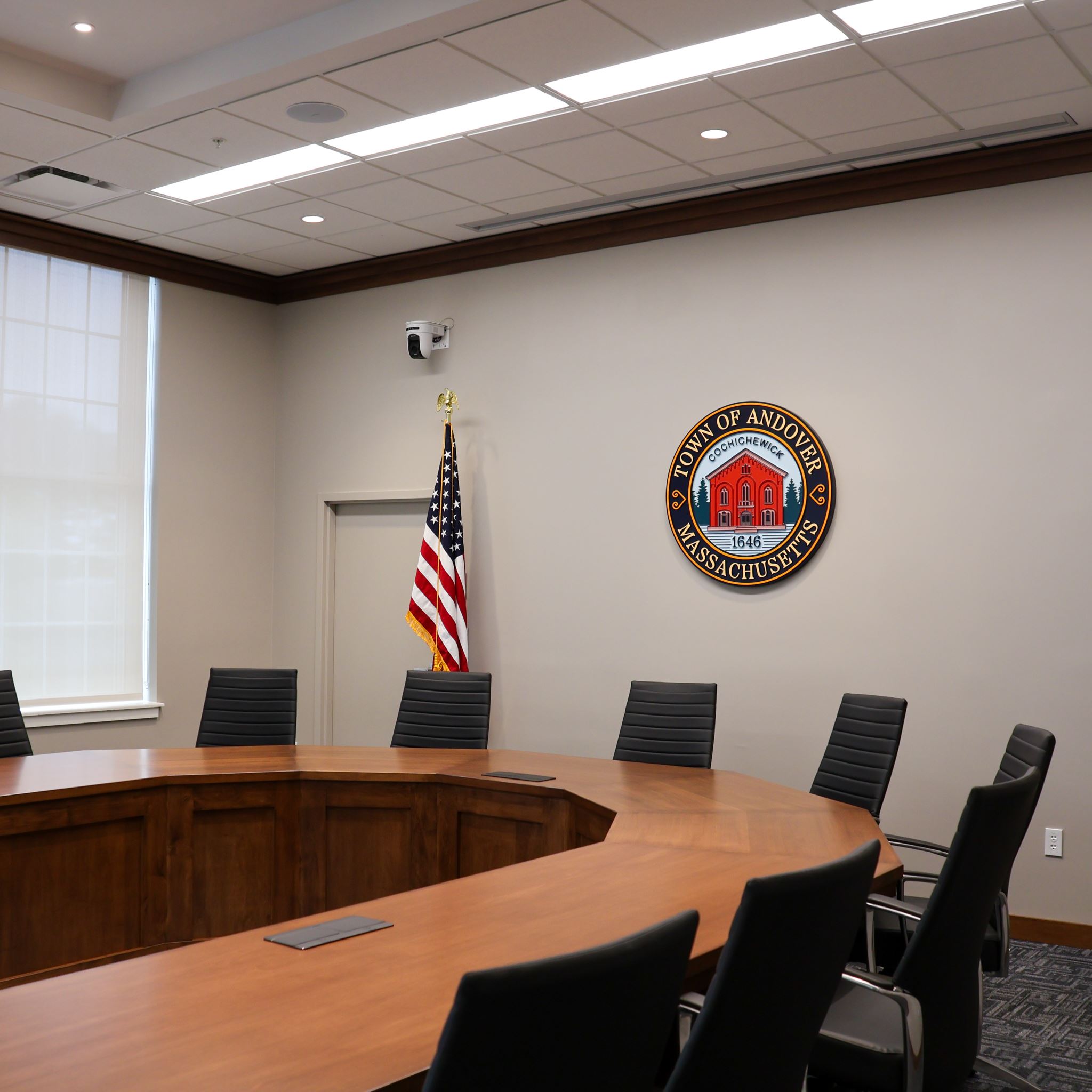 Chairs arrange around a formal meeting table in the Andover Select Board Room