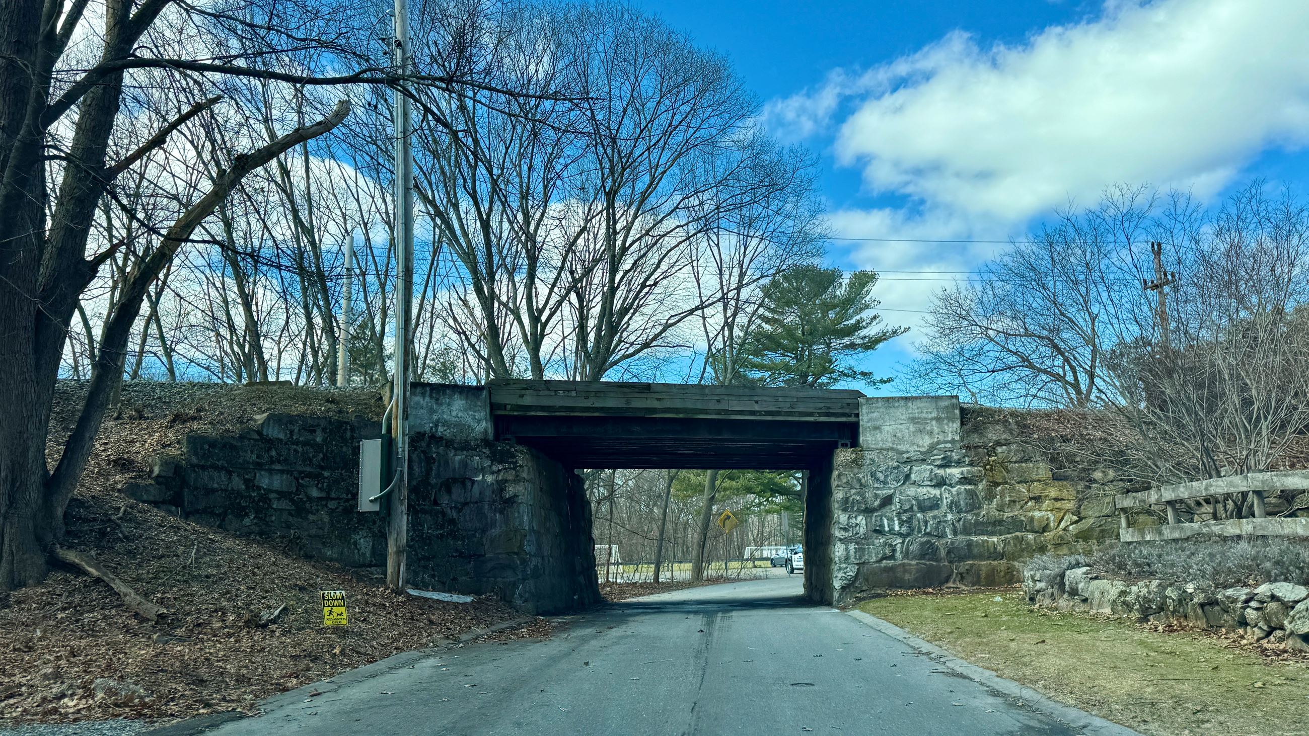 A steel brige spanning two stone walls with a road beneath it
